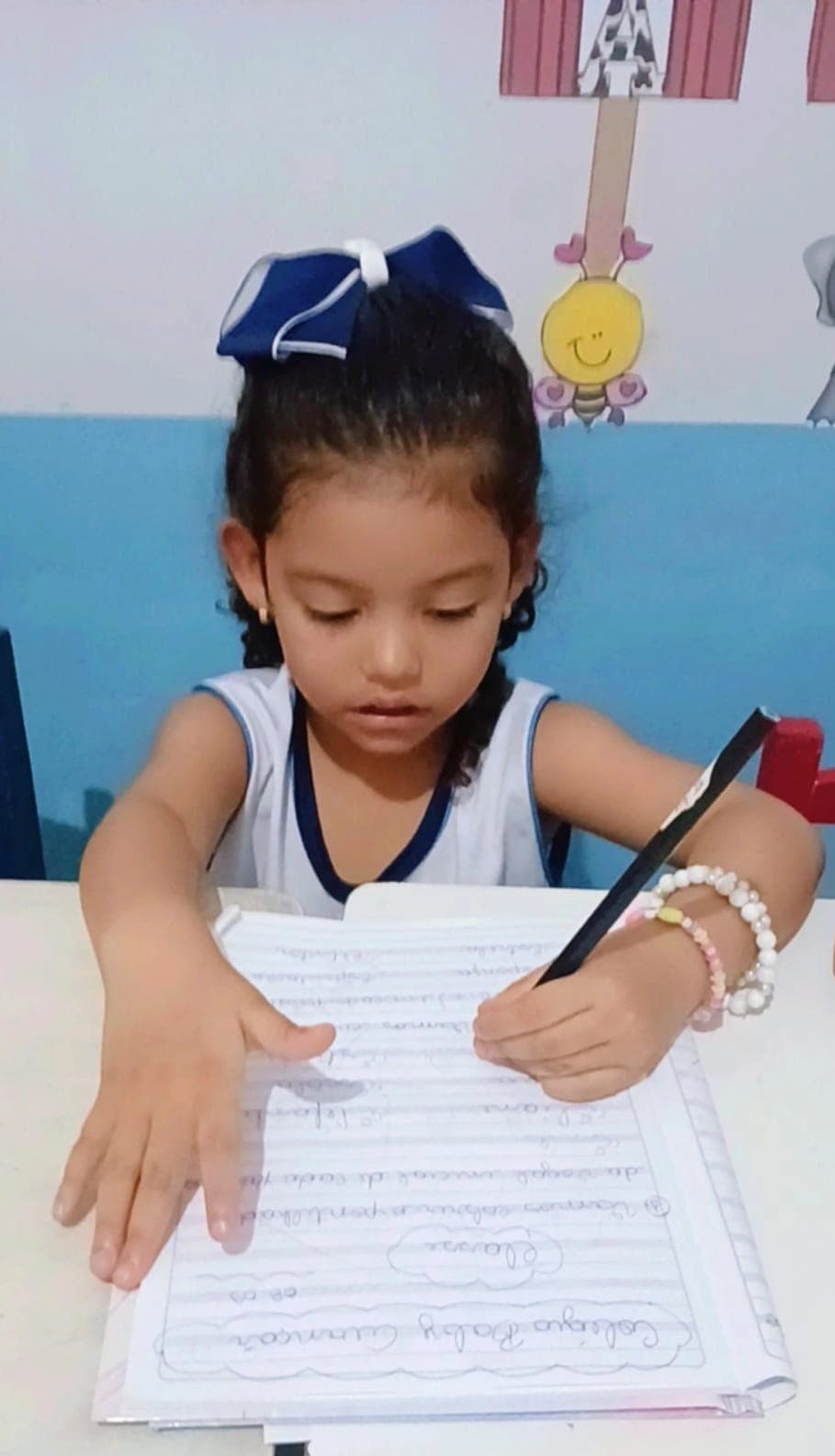 Criança do Fundamental I registrando atividade escrita em caderno do Colégio Baby Avançar